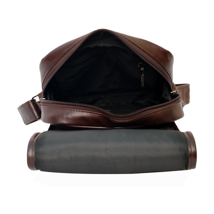 A brown PU leather sling bag with a zippered compartment and an adjustable shoulder strap